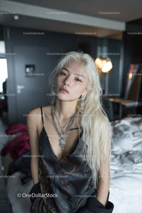 Young Woman with Platinum Blonde Hair Wearing Silver Jewelry in Modern Interior