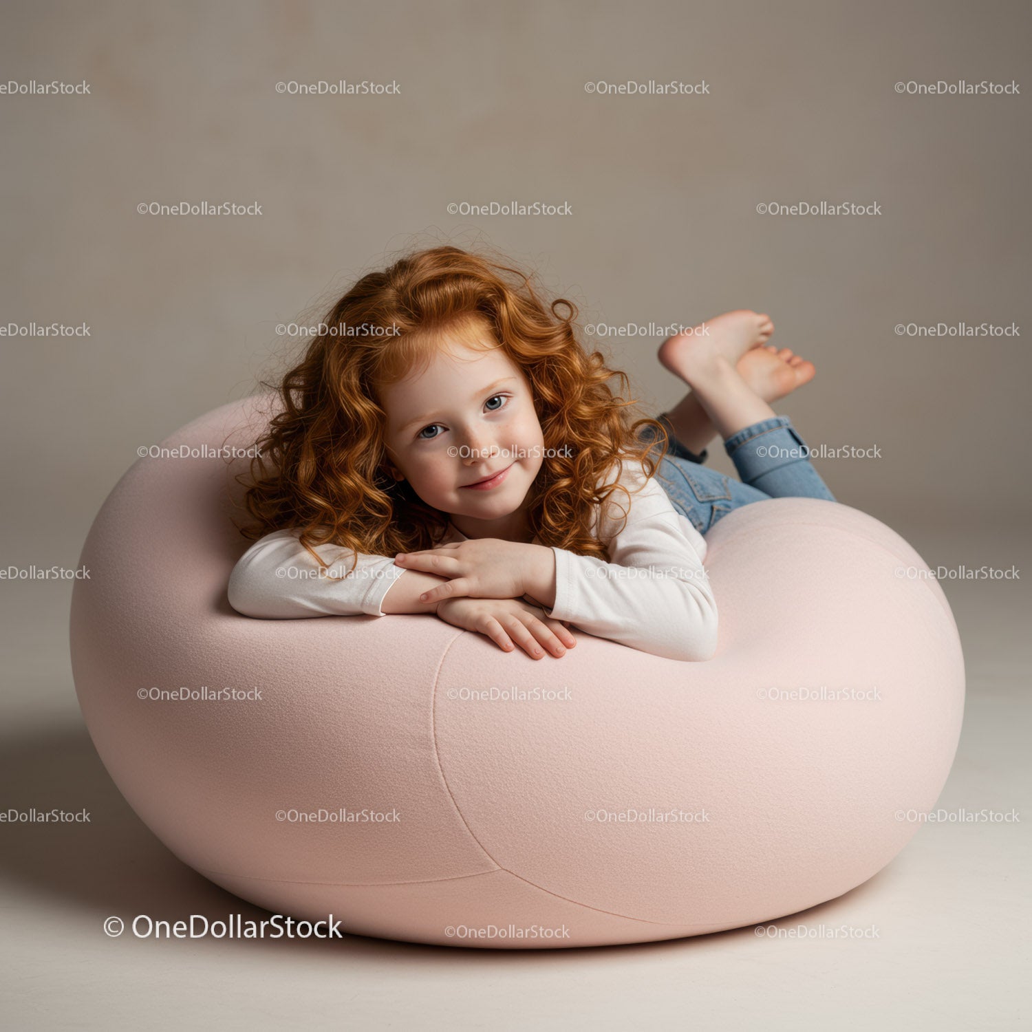 Smiling redhead girl relaxing on a soft pink chair