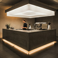 Barista preparing coffee in modern minimalist cafe interior