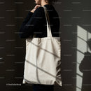 Woman holding blank eco friendly tote bag indoors