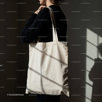 Woman holding blank eco friendly tote bag indoors