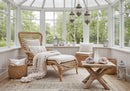 Cozy sunroom with wicker lounge and soft knit blanket
