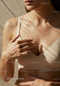 Elegant Woman Applying Body Oil with Sunlit Skin and Beige Top