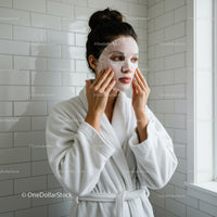 Woman Applying Facial Mask in Bathrobe for Skincare Routine
