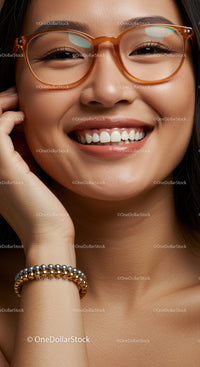 Smiling woman with stylish amber glasses and beaded bracelet