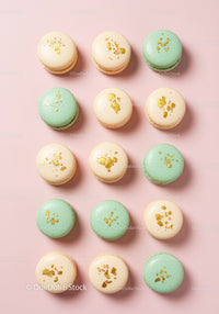 Pastel macarons with golden decoration on pink background