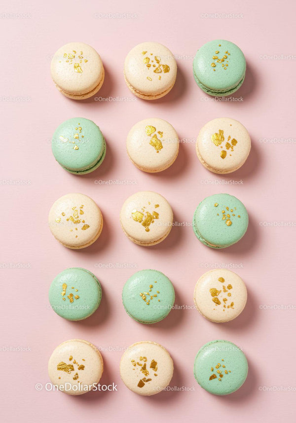 Pastel macarons with golden decoration on pink background