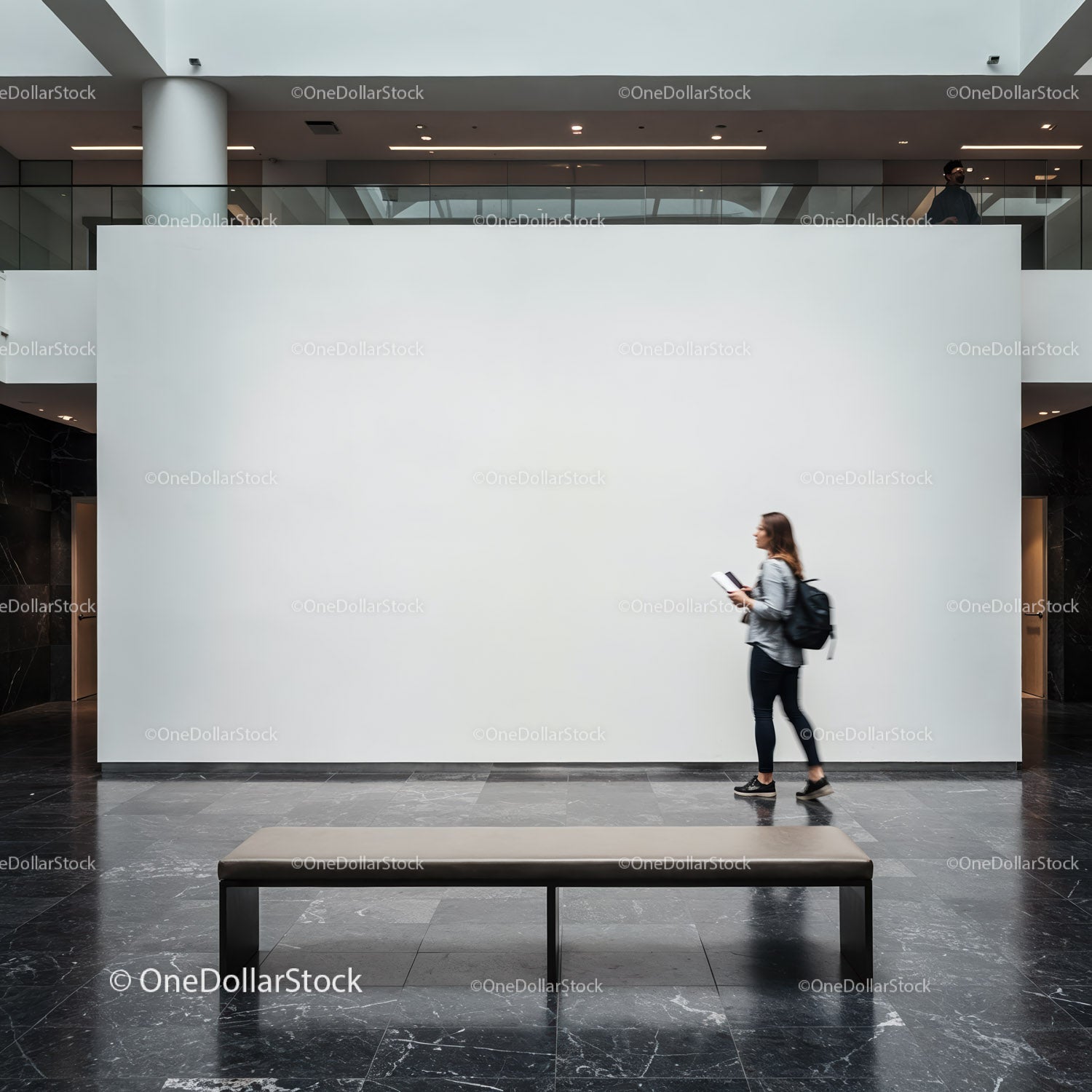 Woman walking past blank gallery wall in modern museum