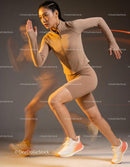 Focused woman sprinting dynamically in beige sportswear