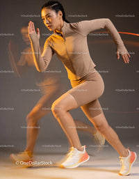 Focused woman sprinting dynamically in beige sportswear