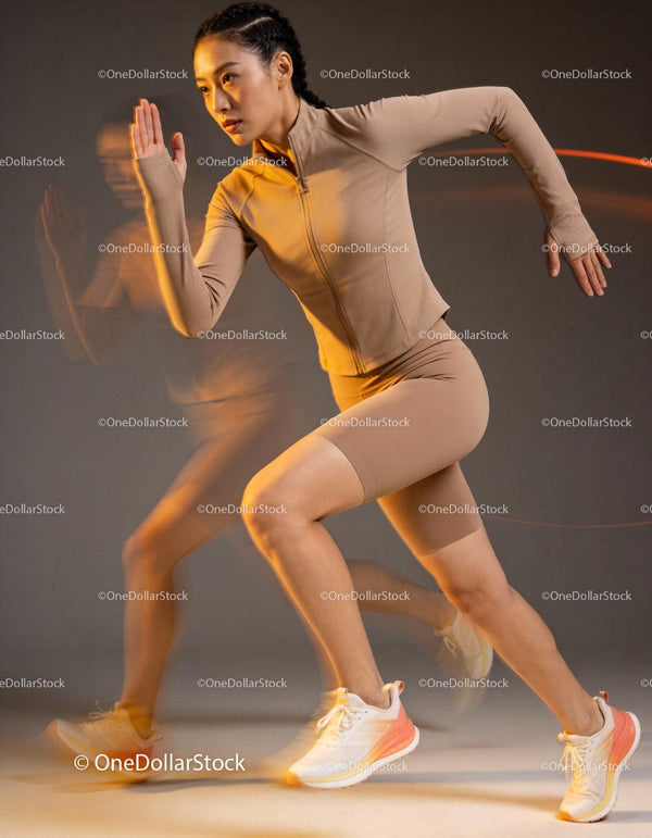 Focused woman sprinting dynamically in beige sportswear
