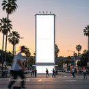 Busy street scene with blank billboard at sunset