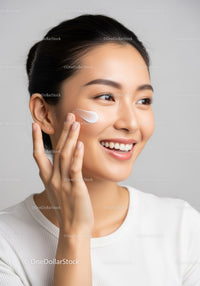 Young Woman Applying Skincare Cream with a Bright Smile