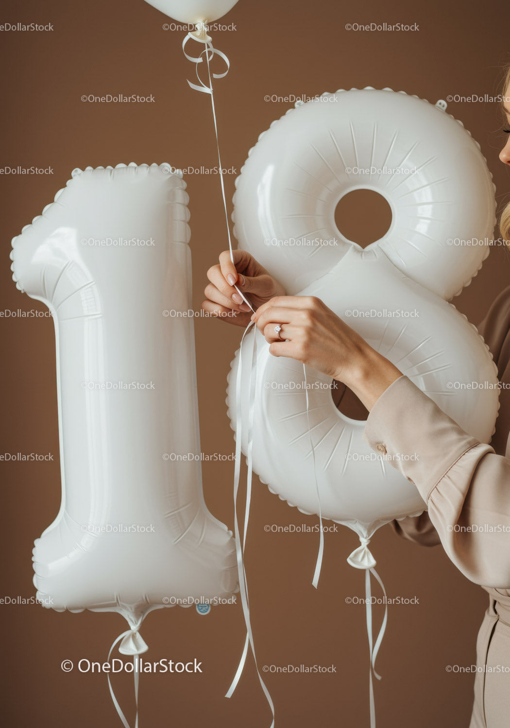 Dłonie wiążące wstążki na 18 białych balonach urodzinowych