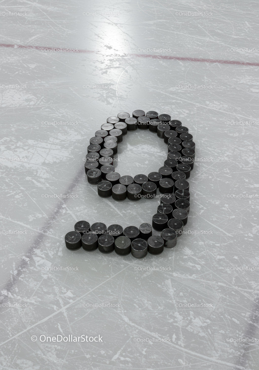 Ice hockey pucks arranged in number nine on rink