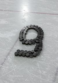 Ice hockey pucks arranged in number nine on rink