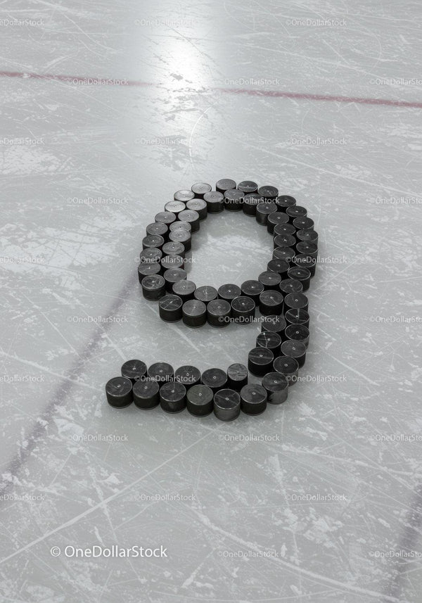 Ice hockey pucks arranged in number nine on rink