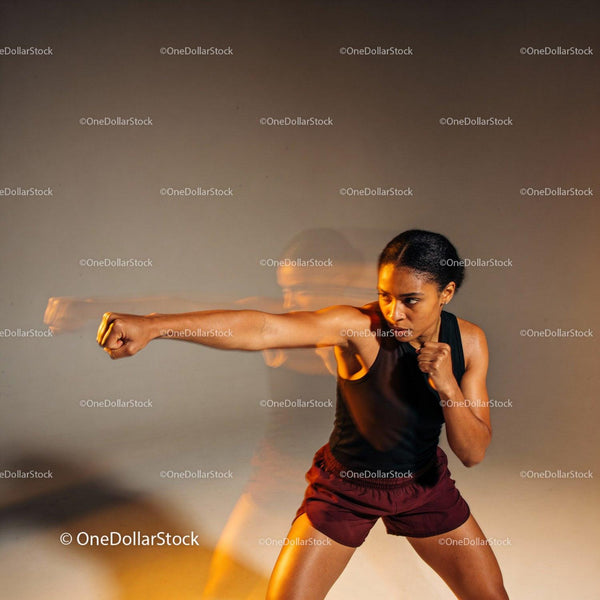 Focused woman practicing boxing punch in studio workout