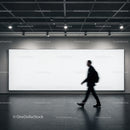Silhouette of businessman walking past blank billboard