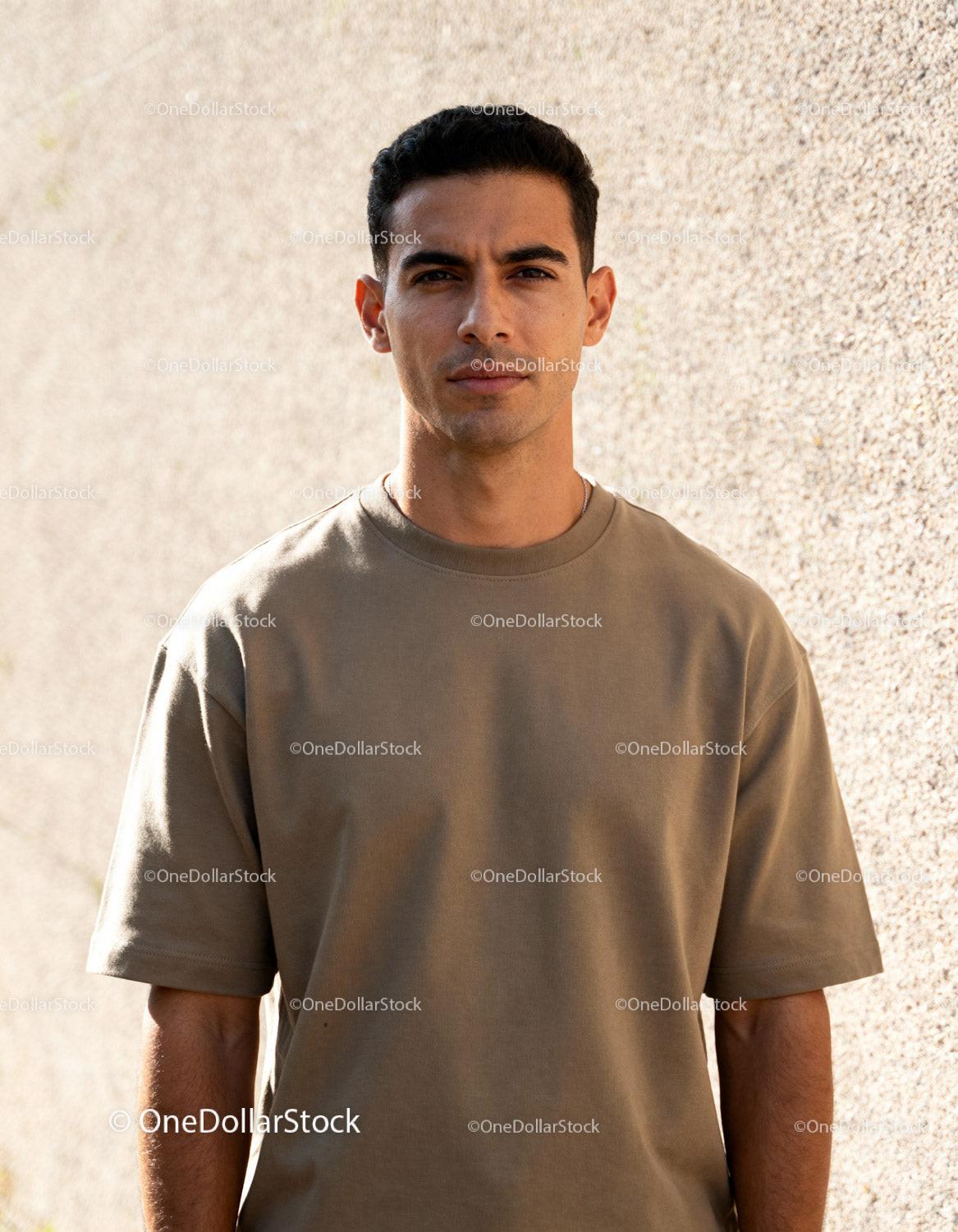 Young man in casual outfit standing by textured wall