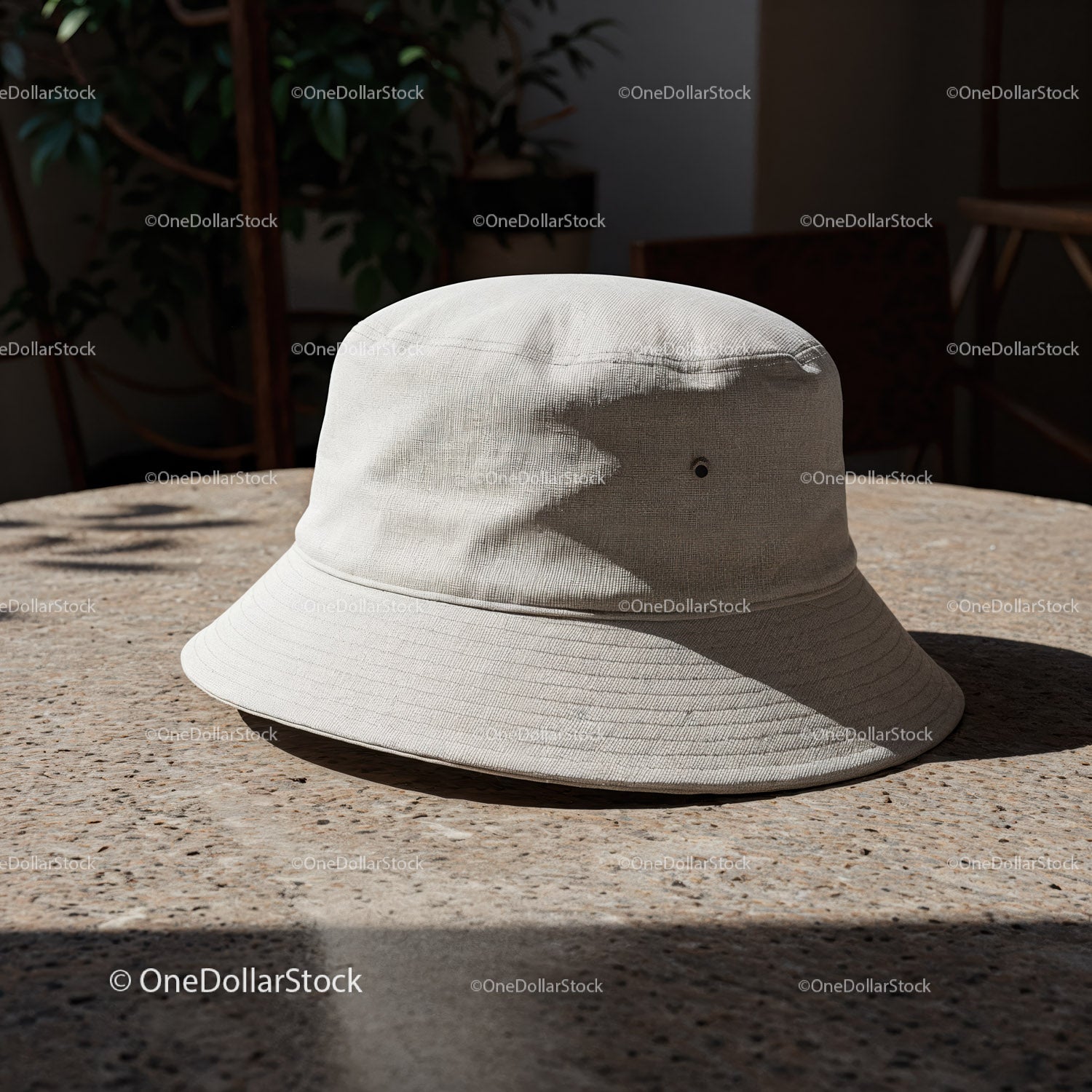 Minimalistyczny beżowy kapelusz typu bucket na teksturowanym stole na zewnątrz