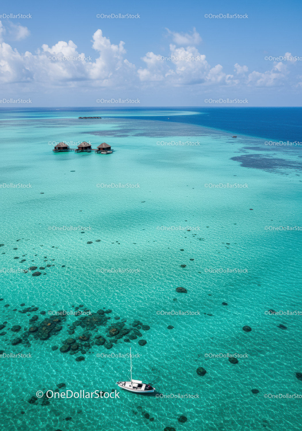 Tropical Overwater Bungalows and Sailing Boat in Clear Blue Sea