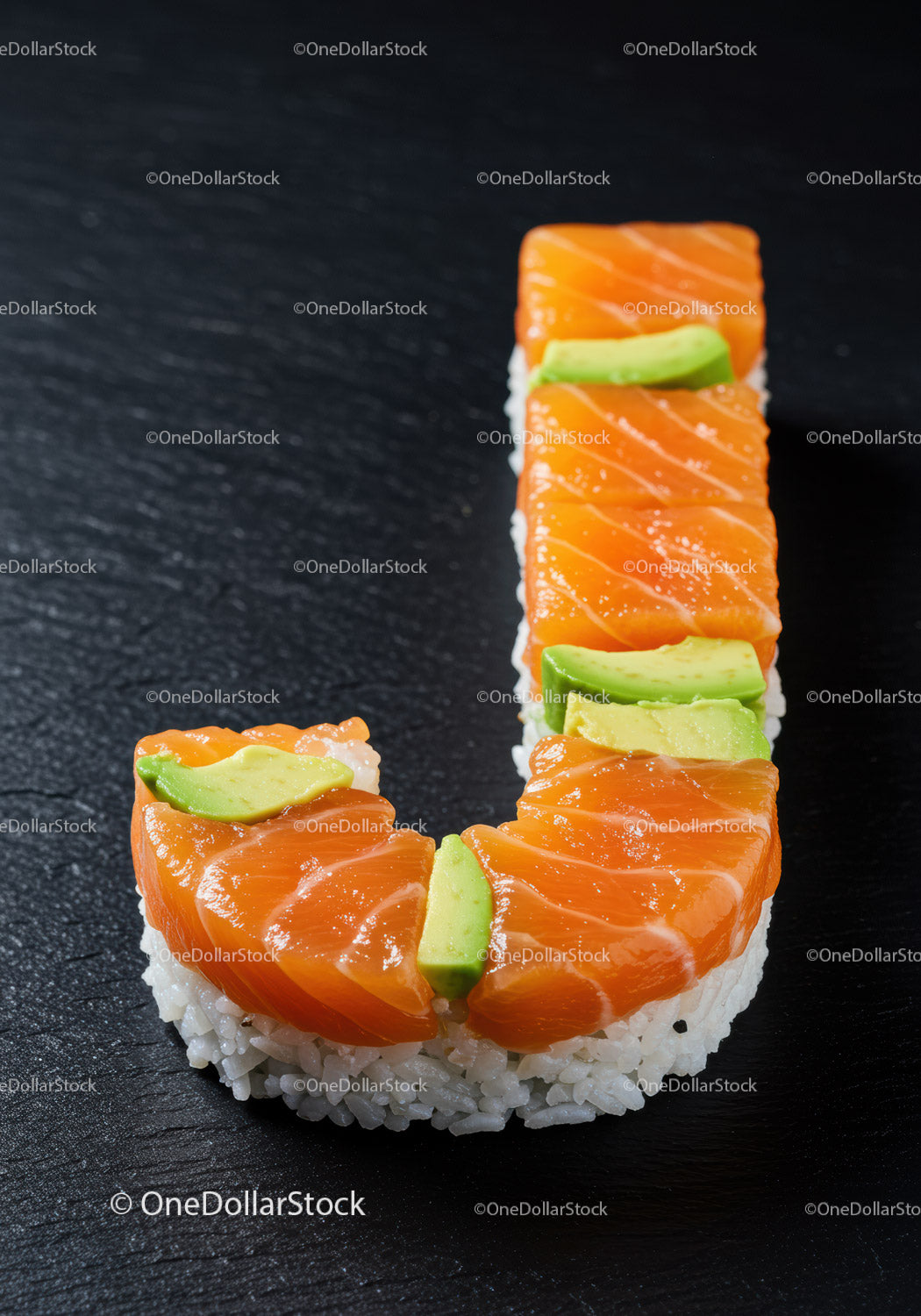 Kawałki sushi ułożone w literę J na ciemnej powierzchni