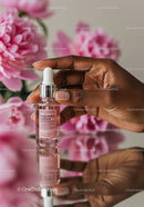 Close Up of Hand Holding Glass Dropper Bottle with Pink Serum