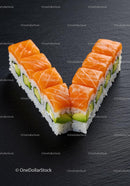 Fresh salmon sushi rolls arranged in a V shape on slate