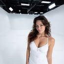 Young Woman in White Dress Standing in Modern Studio