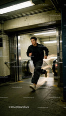 Young man running through urban subway with style