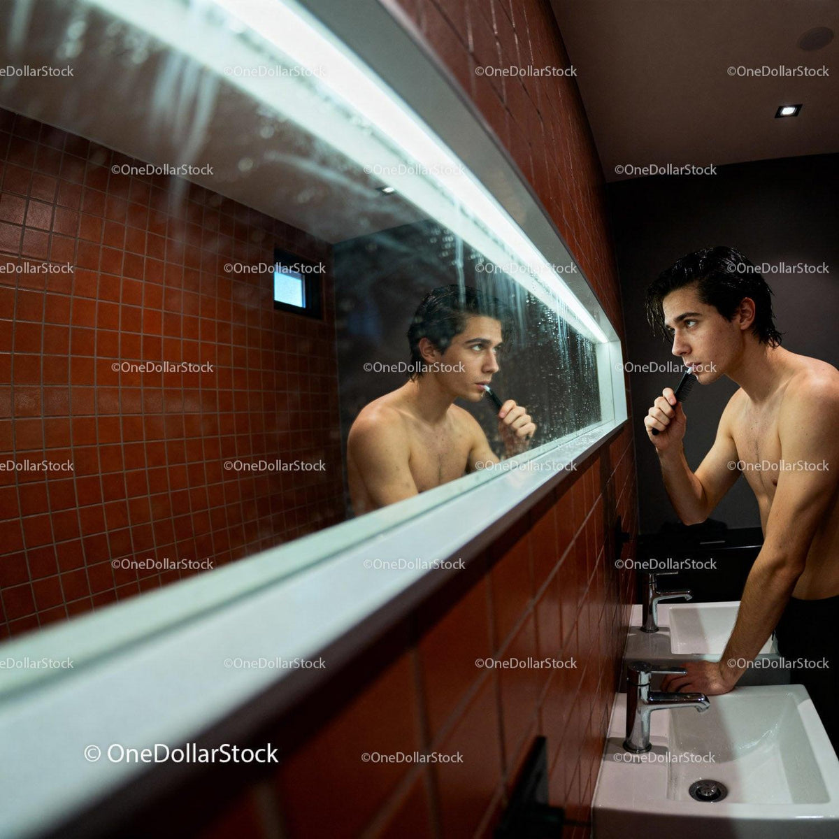 Young man grooming in modern bathroom mirror