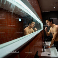 Young man grooming in modern bathroom mirror