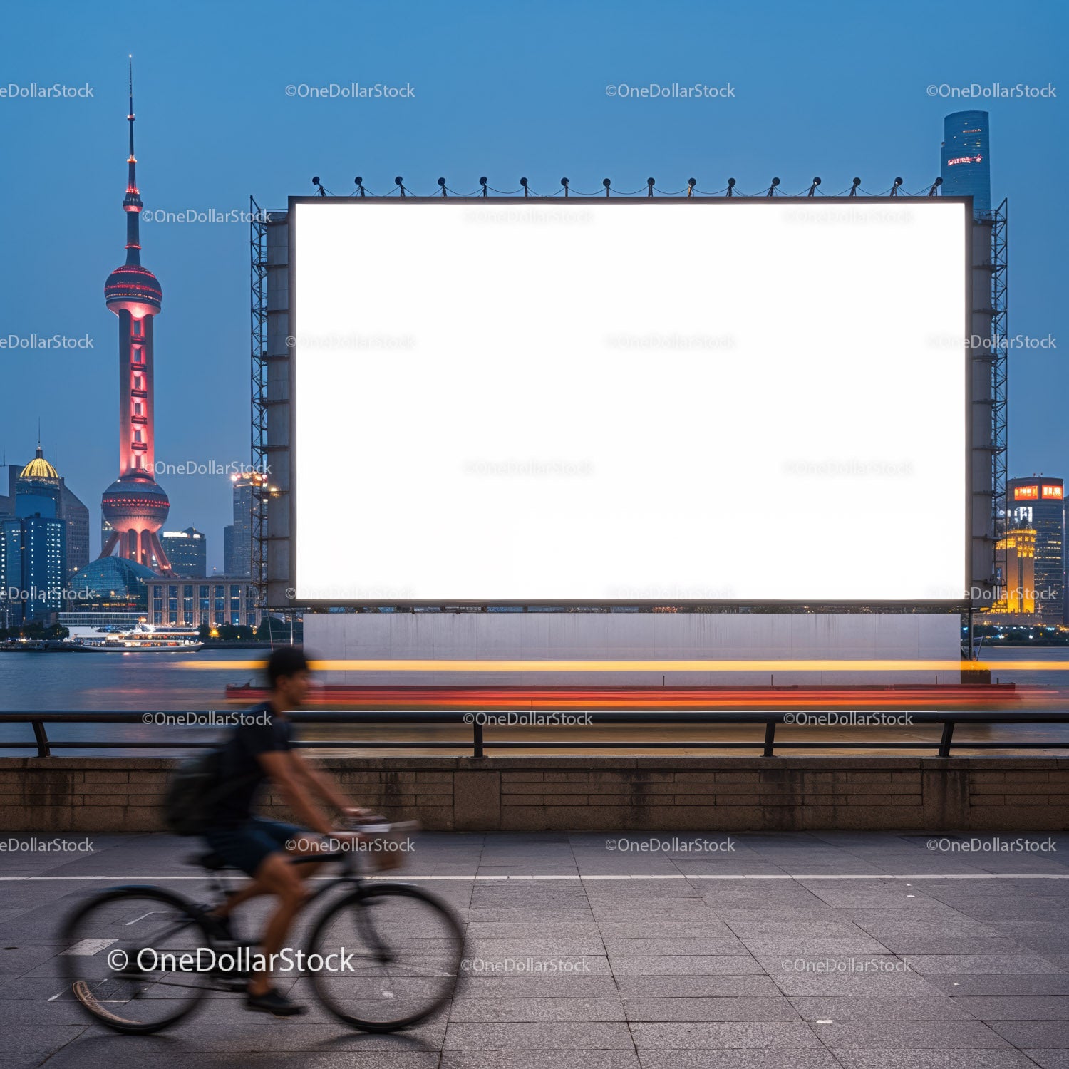 Rowerzysta mija duży, pusty billboard nad brzegiem rzeki