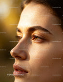 Close up of a woman with natural skin in warm sunlight