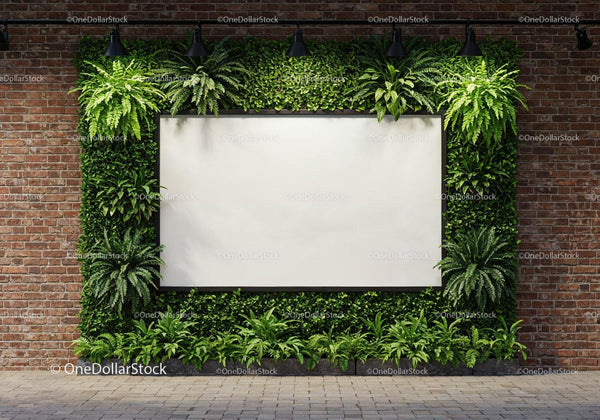 Blank whiteboard surrounded by lush green plants on brick wall JPG Mockup Image