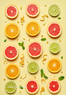 Fresh Citrus Fruit Slices Arranged on Yellow Background
