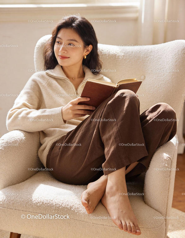 Young woman relaxing with a book on cozy armchair