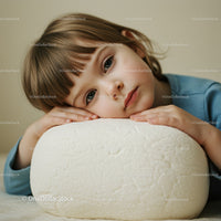 Thoughtful child resting head on soft cushion