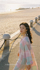 Young woman in pastel dress enjoying a sunny beach walk