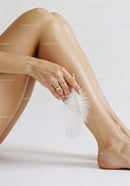 Woman's Smooth Legs with Feather in Minimalist Style