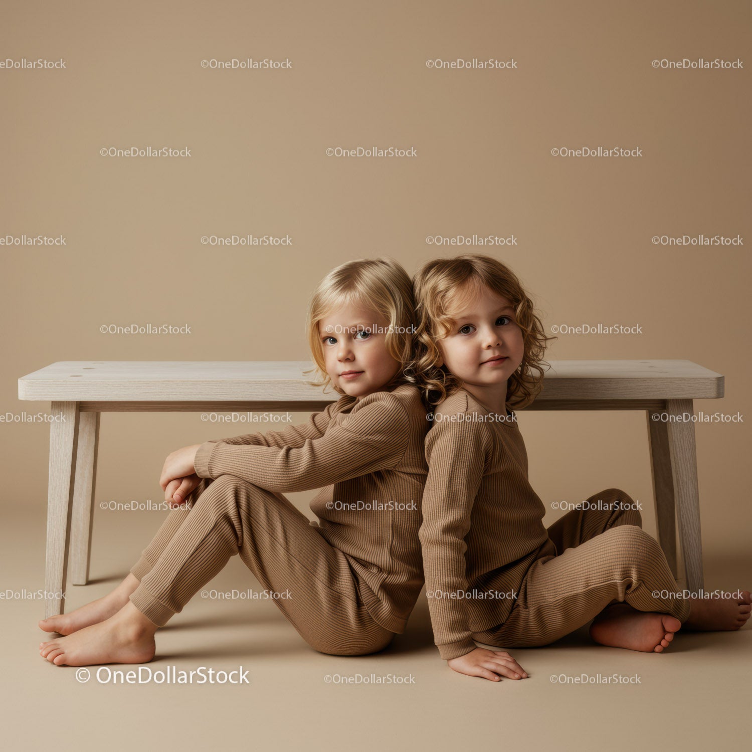 Two children sitting back to back on beige background