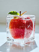 Fresh red apple frozen inside transparent ice cube