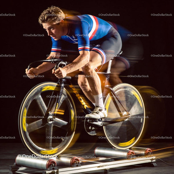 Focused cyclist training intensely on indoor rollers