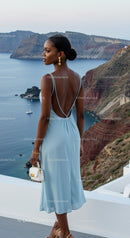 Elegant woman in blue dress overlooking sea cliffs