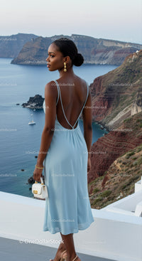 Elegant woman in blue dress overlooking sea cliffs