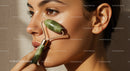 Close-up of woman with Asian features using jade roller for facial massage