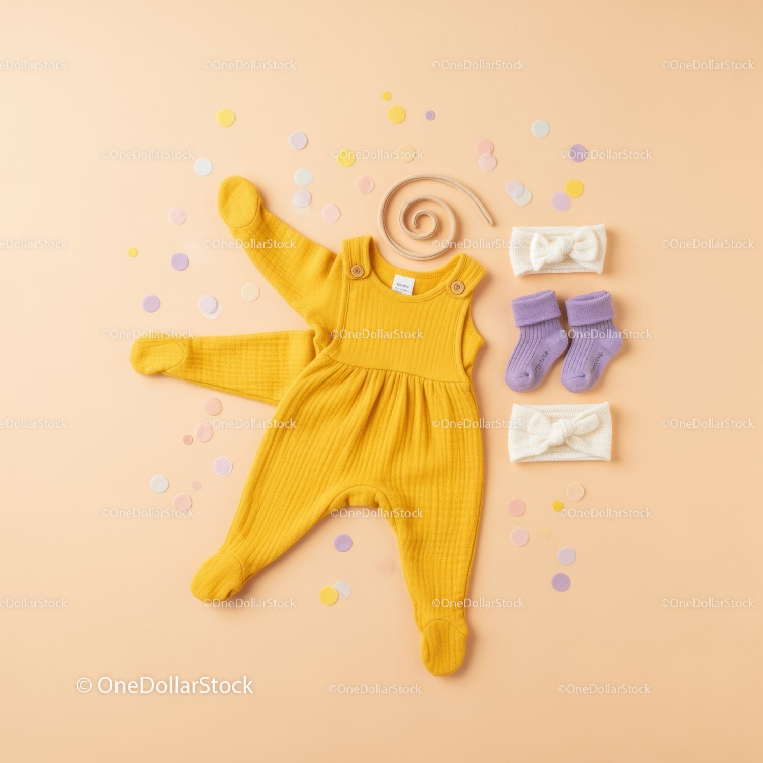Yellow baby romper with purple socks and headbands flat lay