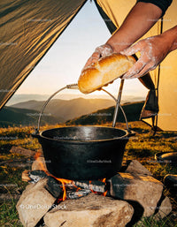 Hands Placing Fresh Bread over Campfire Pot at Sunset