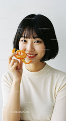 Smiling Woman with Orange in Bright Studio Light